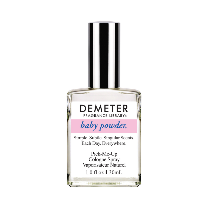 A bottle of Demeter Baby Powder Cologne Spray with a silver cap, white label, and pink color band with baby blue writing.